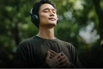 Person relaxing outdoors with headphones